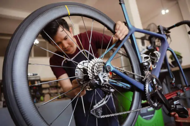 bicycle mechanic checking the parts on a bike looking at the accessories crank derailleur rear front